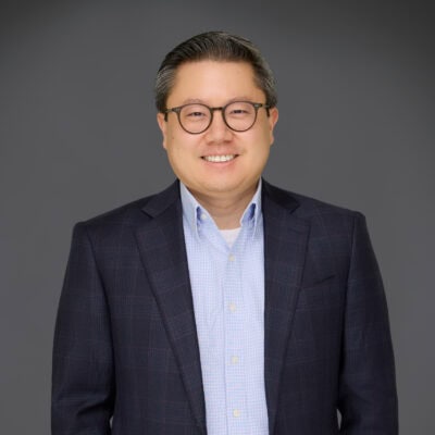 Portrait of Sam Jung, smiling, in professional attire for Maslow's Communities.