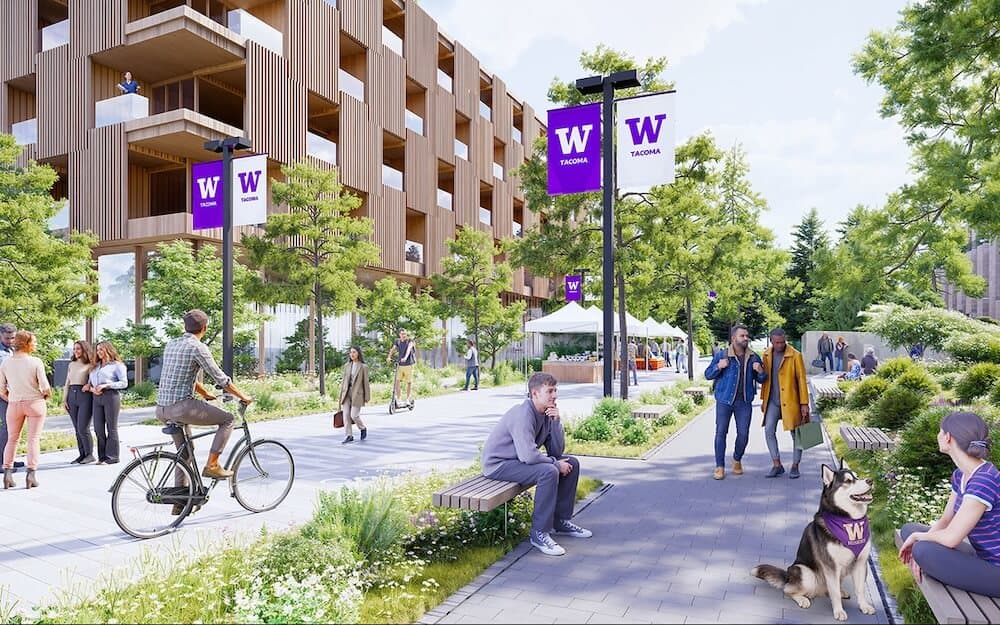 Students and visitors at Maslow's Campus Communities with University of Washington banners.